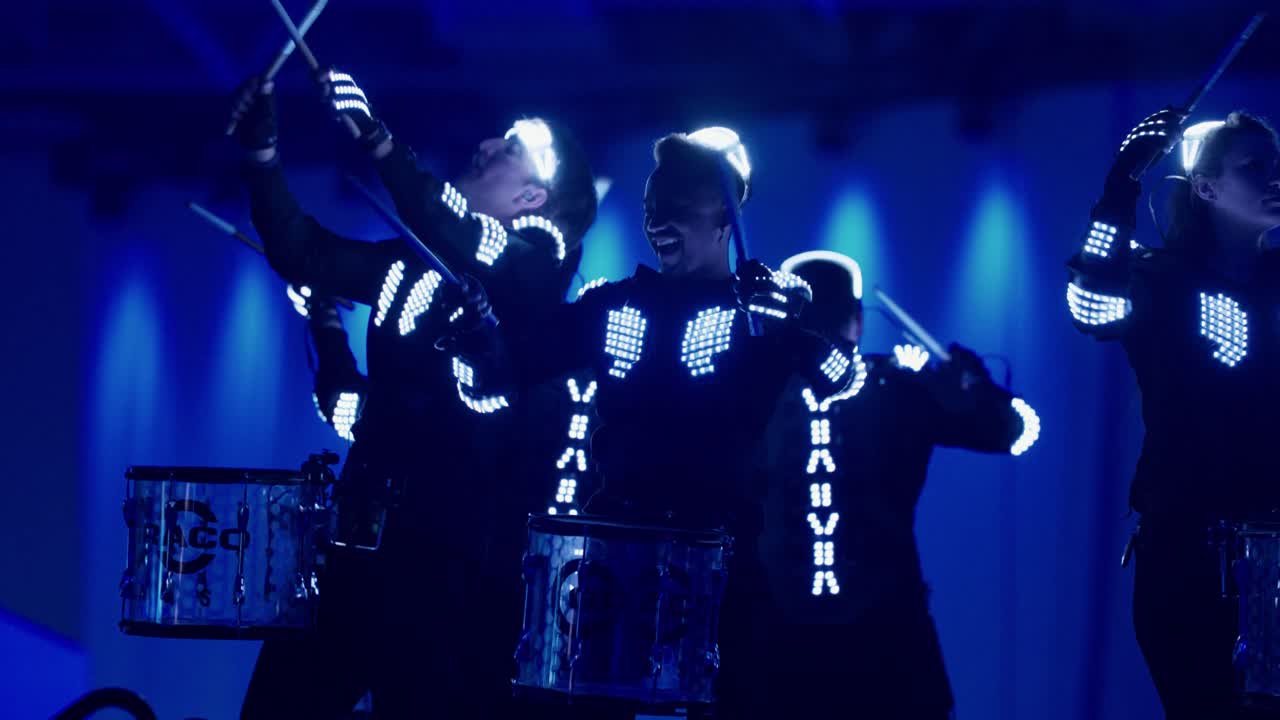 Blue-lit performers at the Graco centennial event
